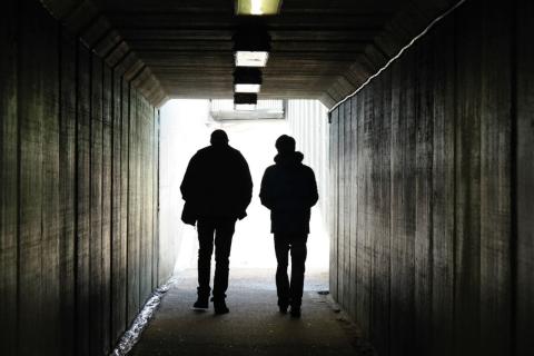 Two men walking throught a tunnel